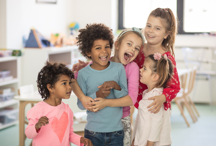 Group of young children hugging and smiling