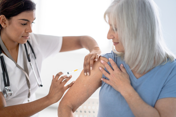 Nurse giving vaccination to patient